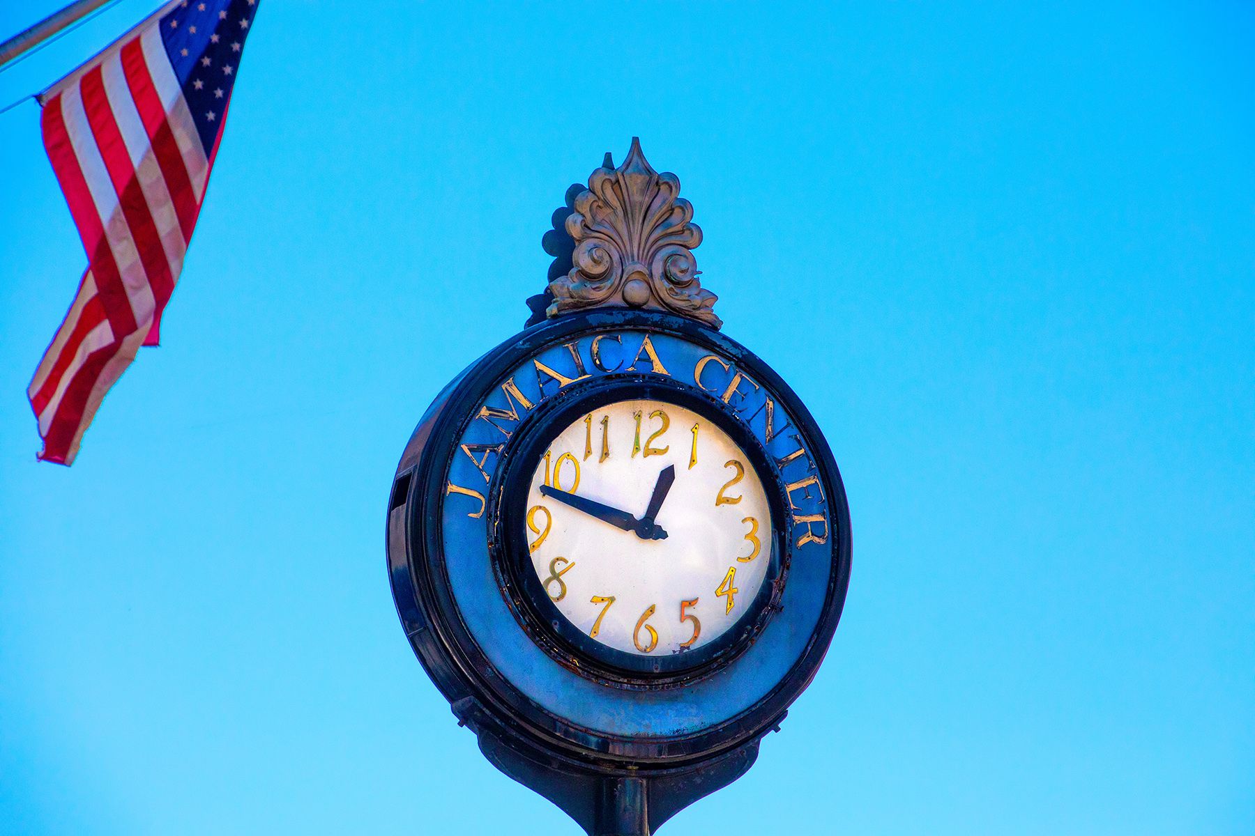 Jamaica Center clock with US flag in corner of photo
