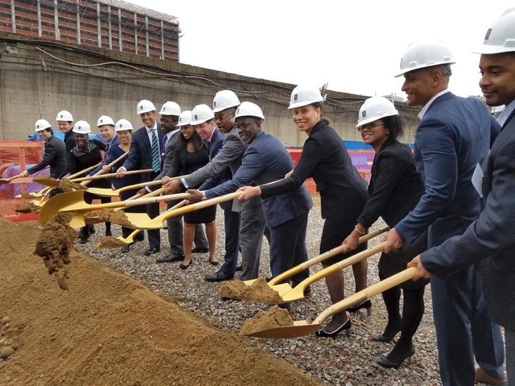 Photo of Team in construction hats with shovels and dirt at a groundbreaking ceremony