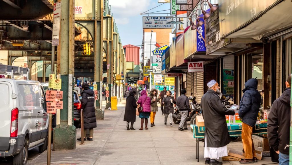 People on the sidewalk walking and talking, wearing coats in the city