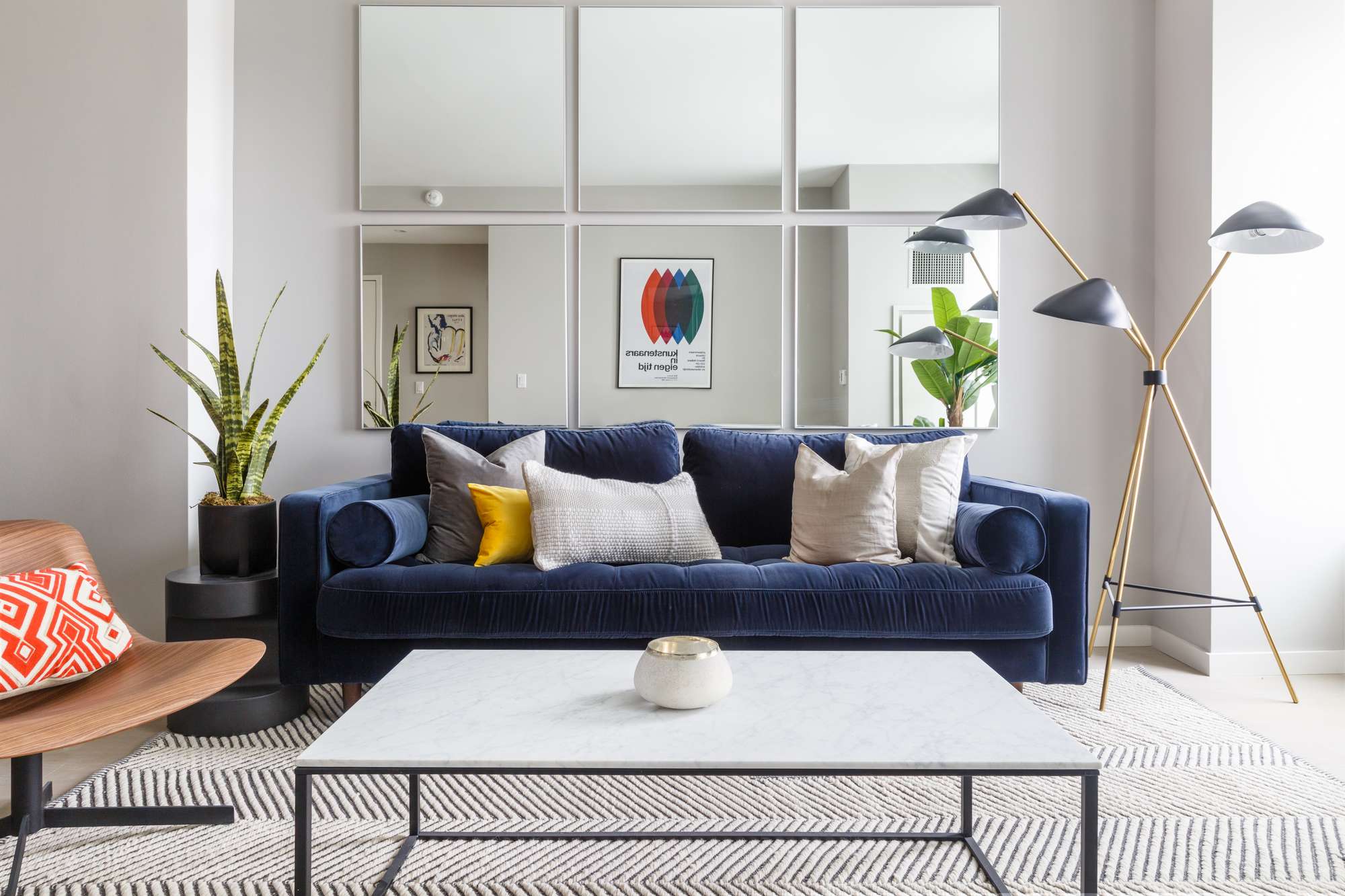 Modern living room with blue couch, decorative pillows, white coffee table